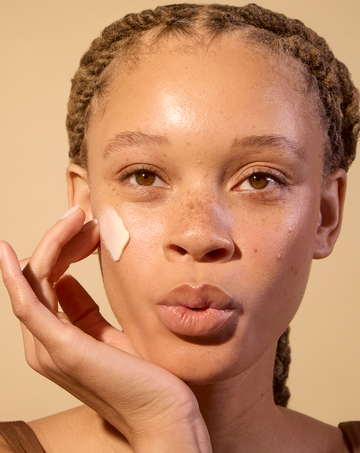 Woman applying non toxic, vegan face moisturizer